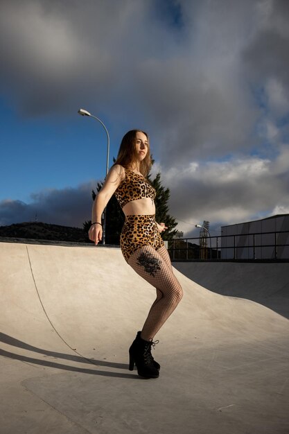 Retrato de una hermosa chica posando en una rampa de skate Atractiva chica posando cerca de una rampa de skate