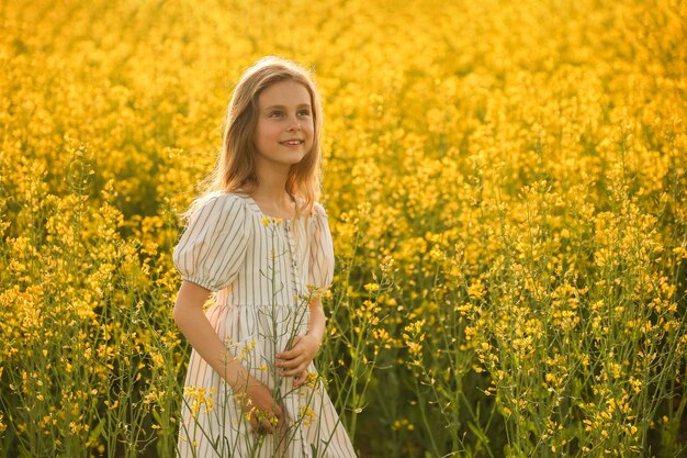 Retrato de una hermosa felicidad niña en el vestido sobre un fondo amarillo natural con