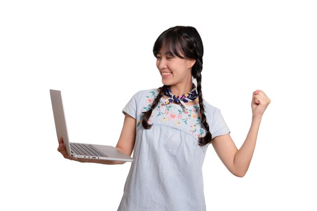 Retrato de una hermosa y feliz joven mujer asiática independiente vestida de mezclilla usando un trabajo portátil con éxito en el fondo blanco