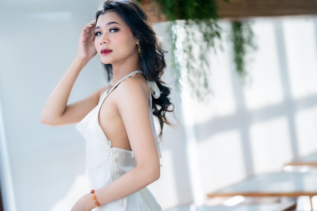Retrato hermosa gente asiática mujer de negocios modelo de moda en vestido blanco sin mangas de verano y café en taza en cafetería