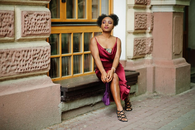 Retrato de una hermosa joven africana natural con cabello afro Modelo negro con vestido de seda roja