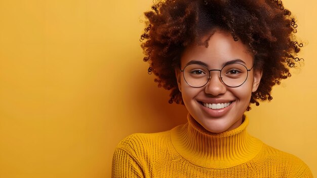 Retrato de una hermosa joven afroamericana con anteojos sonriendo a la cámara aislada sobre amarillo