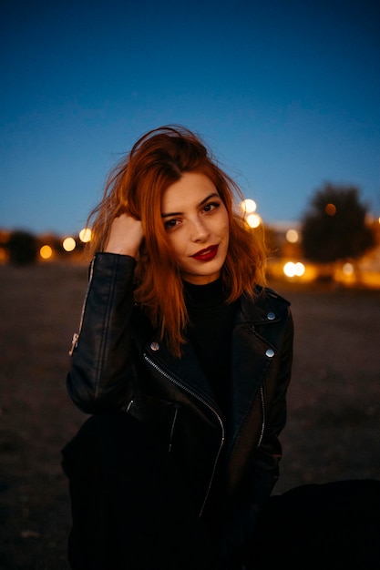 Retrato de una hermosa joven con aire rojo al atardecer. foto de alta calidad