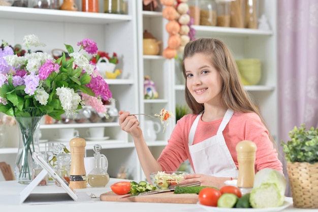 Retrato de una hermosa joven cocinando en la cocina de casa