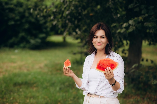 Retrato de una hermosa joven comiendo sandía Foto de alta calidad