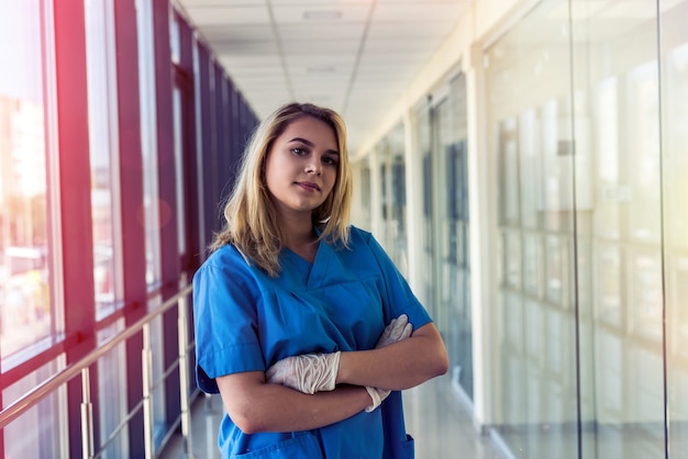 Retrato de hermosa joven enfermera en azul inofrm en clínica. cuidado de la salud