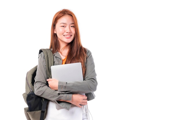 Foto retrato de una hermosa joven estudiante sonriente que sostiene un libro de texto y una computadora portátil que estudia el sistema de aprendizaje electrónico en línea