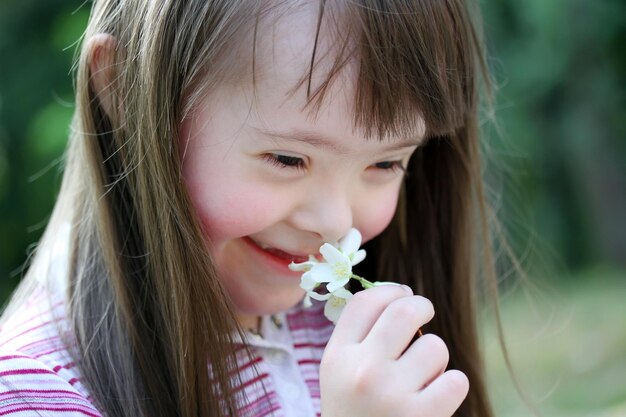 Retrato de una hermosa joven con flores en el parque