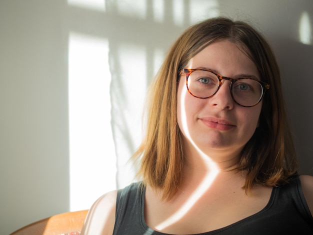 Retrato de una hermosa joven con gafas segura de sí misma y de sus pensamientos