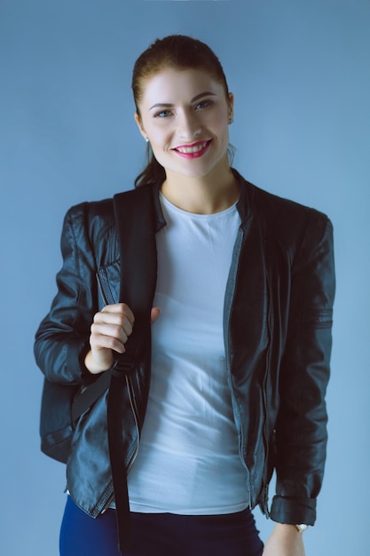 Retrato de una hermosa joven morena con elegante chaqueta negra en gris