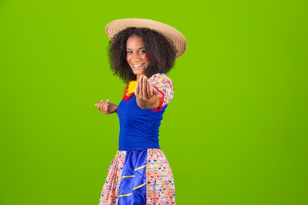 Foto retrato de una hermosa joven negra vestida para la festa junina bailando un forro joven mujer afro con traje de festa junina