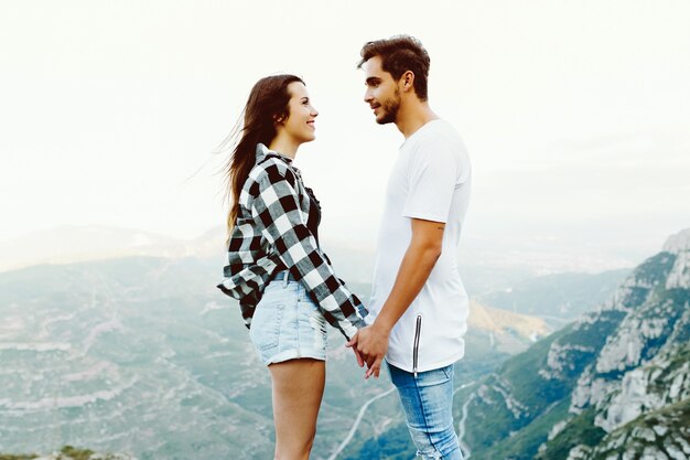 Retrato de hermosa joven pareja disfrutando de la naturaleza en el pico de la montaña.