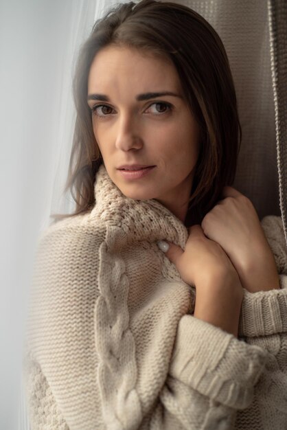 retrato de una hermosa joven con el pelo largo en un suéter acogedor