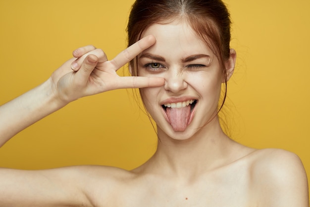 Retrato de una hermosa joven con una piel hermosa sobre un fondo amarillo