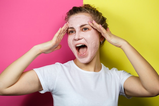 Retrato de una hermosa joven que se pone una mascarilla refrescante en el rostro para rejuvenecer y tonificar la piel. Tratamientos de belleza