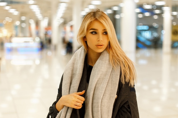 Foto retrato de una hermosa joven rubia en ropa de moda en el interior