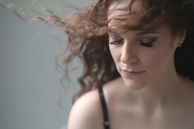 Retrato de una hermosa joven sensual con cabello rizado