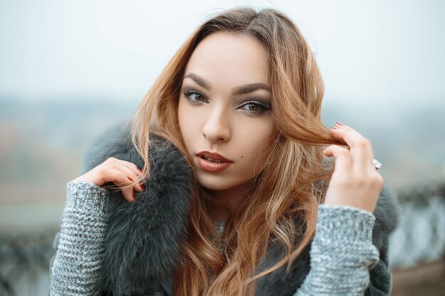 Retrato de una hermosa joven sobre un fondo de niebla