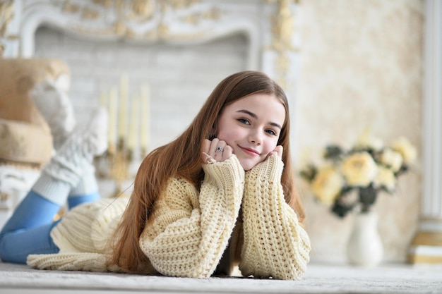 Retrato de una hermosa jovencita acostada en el suelo en la habitación