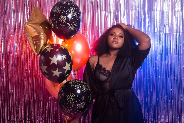 Retrato de una hermosa mujer afroamericana contra el fondo centelleante. Fiesta de cumpleaños