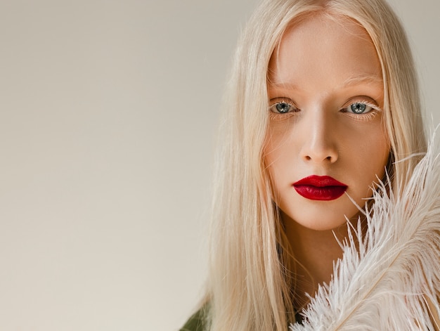 Foto retrato de hermosa mujer albina con pluma blanca