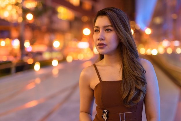 Retrato de hermosa mujer asiática al aire libre en Bangkok, Tailandia por la noche