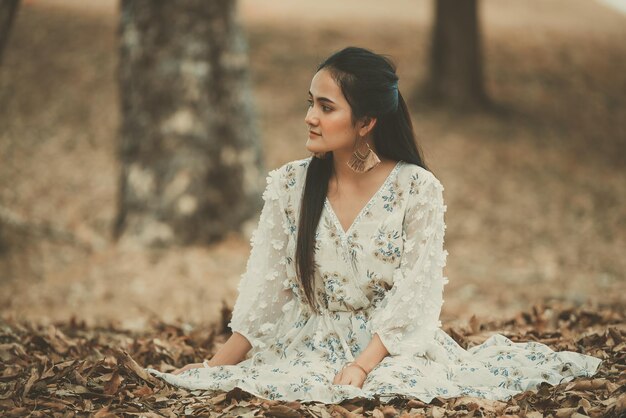 Retrato de hermosa mujer asiática en el bosque con hojas secasGente de TailandiaLa primavera