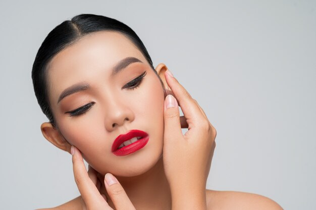 Retrato de hermosa mujer asiática con cabello negro y labios rojos