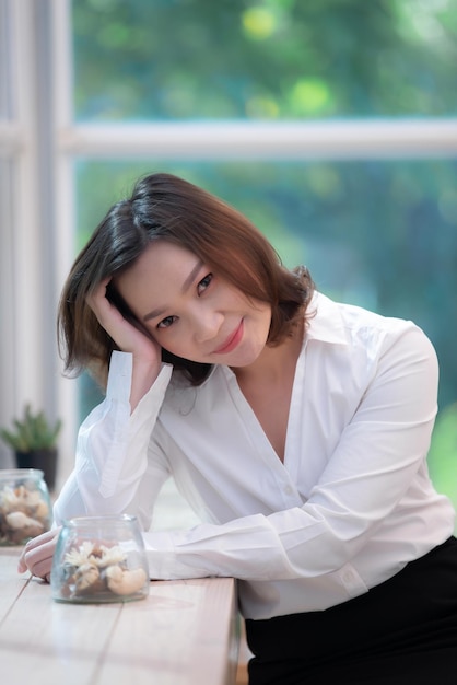 Retrato de hermosa mujer asiática en la cafeteríaTiempo de relajaciónGente de Tailandia trabajando