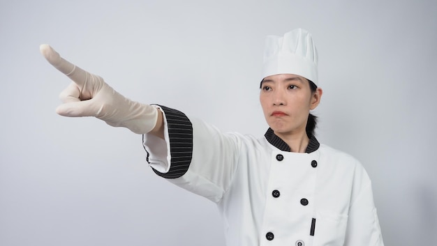 Retrato hermosa mujer asiática cocinera con uniforme de chef haciendo gesto