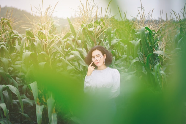 Retrato de hermosa mujer asiática disfrutar al aire libre natural en el campo de maíz