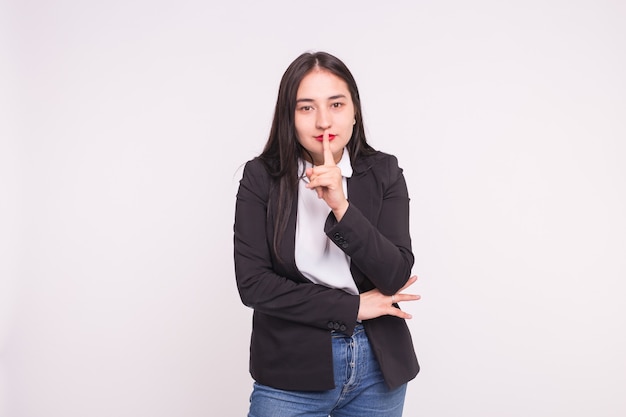 Retrato de hermosa mujer asiática haciendo gesto de silencio en blanco con espacio de copia.