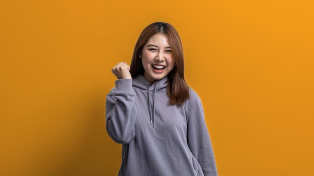 Retrato de una hermosa mujer asiática haciendo una pose alegre en un concepto de retrato de fondo aislado utilizado para publicidad y señalización aislado sobre un espacio de copia de fondo amarillo