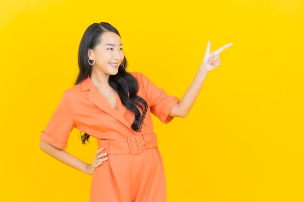 Retrato hermosa mujer asiática joven sonrisa con acción en amarillo