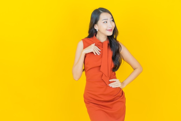 Retrato hermosa mujer asiática joven sonrisa con acción en amarillo