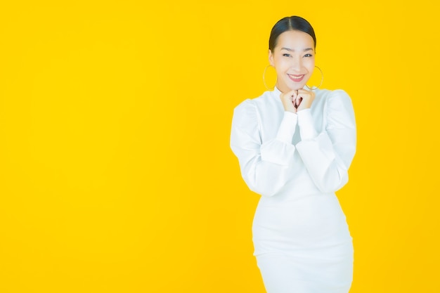 Retrato hermosa mujer asiática joven sonrisa con acción en amarillo