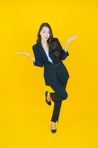 Retrato hermosa mujer asiática joven sonrisa con acción en amarillo