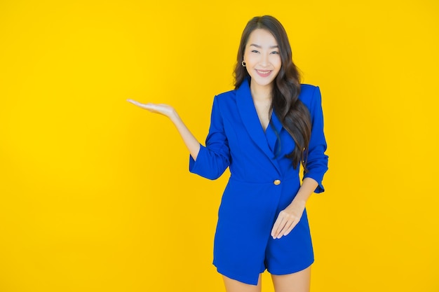 Retrato hermosa mujer asiática joven sonrisa con acción en amarillo