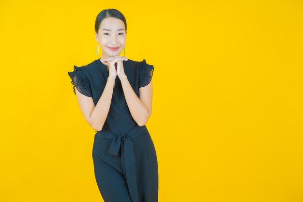 Retrato hermosa mujer asiática joven sonrisa en amarillo