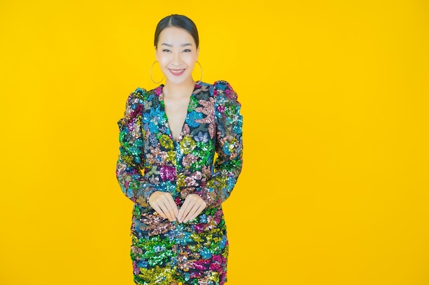 Retrato hermosa mujer asiática joven sonrisa en amarillo