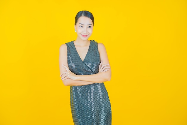 Retrato hermosa mujer asiática joven sonrisa en amarillo