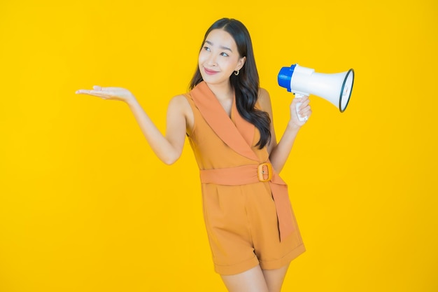 Retrato de hermosa mujer asiática joven sonrisa con megáfono