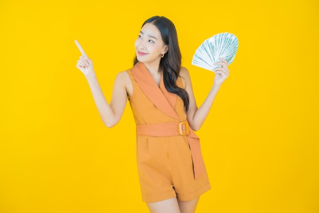 Retrato de hermosa mujer asiática joven sonrisa con mucho dinero en efectivo y dinero