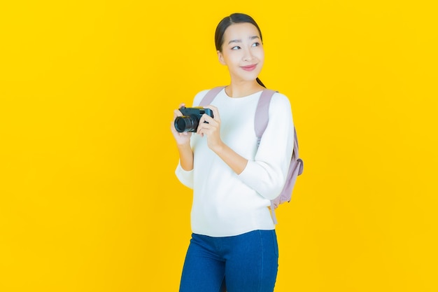 Retrato hermosa mujer asiática joven usar cámara en amarillo