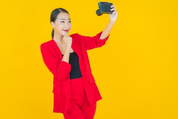 Retrato hermosa mujer asiática joven usar cámara en amarillo