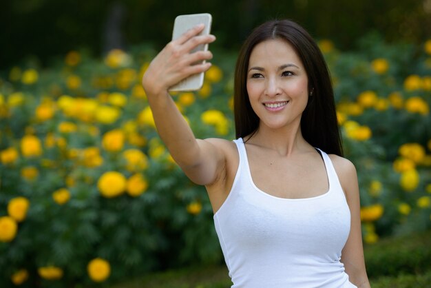 Retrato de hermosa mujer asiática relajante en el parque al aire libre