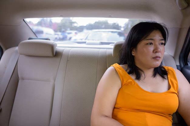 Retrato de hermosa mujer asiática con sobrepeso dentro del coche alrededor de la ciudad de Bangkok, Tailandia