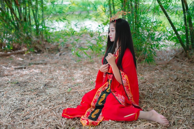 Retrato de una hermosa mujer asiática vestida con un antiguo estilo chino en el bosque de bambúGente tailandesaEscena de cine chino