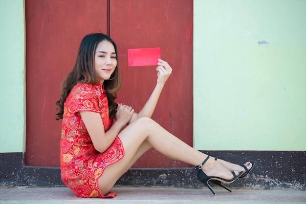 Retrato hermosa mujer asiática en vestido Cheongsam, gente de Tailandia, concepto de feliz año nuevo chino, Hap