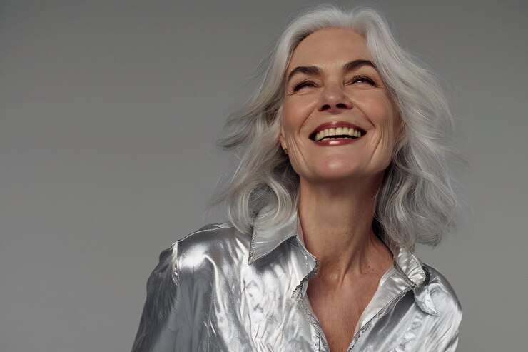 Retrato de una hermosa mujer con cabello blanco sobre un fondo gris